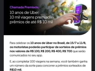 Uma mão segura um smartphone com o aplicativo da Uber aberto, mostrando a promoção "Chamada Premiada" que oferece aos motoristas a chance de ganhar até R$10 mil em dinheiro. Um volante desfocado aparece ao fundo.