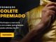 Um homem fecha o zíper de um colete dourado com a logo da XP Investimentos, em um fundo escuro. O colete é o prêmio de uma promoção da XP.