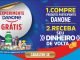 Imagem promocional da Danone com fundo azul. À esquerda, um círculo branco com a frase "Experimente Danone Grátis" em vermelho e azul. Abaixo, uma variedade de produtos Danone, incluindo Activia, Danoninho e Yopro. À direita, instruções em amarelo e branco: "1. Compre produtos participantes Danone 2. Receba seu dinheiro de volta". No rodapé, um botão dourado com "Cadastre-se".
