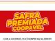 Imagem de um banner promocional da Coopavel com fundo vermelho. No centro, está escrito "Safra Premiada Coopavel" em letras grandes amarelas com bordas brancas. Abaixo do banner, em letras pretas, lê-se "Com a Coopavel você sempre sai na frente".