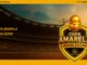 Banner promocional da Copa Amarela John Deere exibindo um grande escudo dourado com uma bola de futebol usando capacete de obra, posicionado à frente de um estádio lotado ao pôr do sol com guindastes de construção ao fundo.