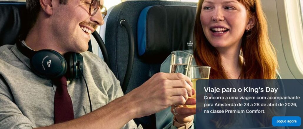 Promoção KLM Kings Day 2026 Homem e mulher brindam com copos de vidro em um voo da KLM em anúncio da promoção para o King's Day 2026 em Amsterdã.