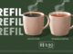 Banner publicitário com fundo verde escuro apresentando a oferta de refil da Starbucks. À esquerda, a palavra REFIL aparece três vezes em letras grandes. No centro, duas canecas cerâmicas beges com a logomarca da sereia contêm café coado e chá, ambos fumegantes. Um quadro no canto inferior direito informa o preço a partir de R$9,90 para o tamanho de 300 ml.