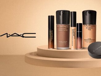 Logotipo da MAC à esquerda e diversos produtos de maquiagem para o rosto das linhas Studio Radiance e Studio Fix dispostos sobre uma plataforma circular bege.