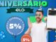 Propaganda do Aniversário Elo com destaque para 5% de cashback. Um homem sorridente com acessórios de festa segura um smartphone que exibe um cartão Elo digital, cercado por balões informativos e elementos festivos sobre um fundo azul.