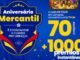 Banner promocional do Aniversário Mercantil com fundo azul e confetes amarelos. À esquerda, um escudo azul e amarelo contém o título da campanha e uma bola de futebol. À direita, o texto informa que a cada R$150,00 em compras o cliente concorre a uma TV de 70 polegadas e mais de 1000 prêmios instantâneos. No topo, uma foto mostra pessoas com camisas amarelas celebrando.