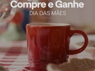 Caneca de ceramica vermelha em destaque sobre uma mesa com toalha xadrez acompanhada pelo texto informativo Compre e Ganhe Dia das Maes.