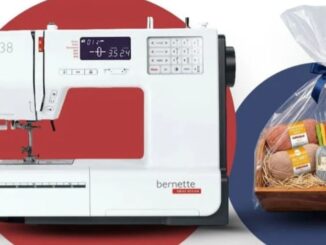 Máquina de costura branca modelo Bernette b38 ao lado de uma cesta de presente com novelos de linha e agulhas de crochê coloridas.