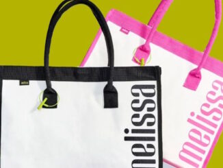 Duas bolsas Melissa Shopper, uma branca com detalhes pretos e outra branca com detalhes rosas, posicionadas sobre um fundo verde.