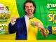 Homem com expressão de comemoração veste uma roupa composta por metade de um terno azul e metade de uma camisa amarela de futebol. O fundo apresenta tons de verde e amarelo com elementos visuais de um estádio. O texto detalha a promoção Grandes Marcas dos supermercados Lopes com prêmios como R$50MIL, televisores, cervejeiras e vales-compra.