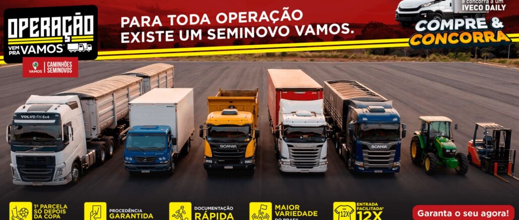 Banner publicitário da Operação Vem Pra Vamos apresentando uma linha diversificada de veículos seminovos, incluindo caminhões Volvo, Mercedes-Benz e Scania, além de trator e empilhadeira, posicionados em um pátio de asfalto sob um céu avermelhado.