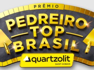 Logotipo do Prêmio Pedreiro Top Brasil da Quartzolit em letras douradas 3D com duas colheres de pedreiro nas laterais sobre um fundo escuro texturizado e borda dourada.