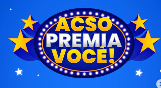 Logotipo da promoção ACSO PREMIA VOCÊ! com letras coloridas dentro de uma moldura oval iluminada sobre um fundo azul com estrelas.