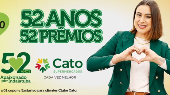 Publicidade de aniversário do Cato Supermercados com uma mulher sorridente fazendo um sinal de coração com as mãos. O texto destaca 52 Anos e 52 Prêmios sobre um fundo claro com tons de verde.
