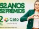 Publicidade de aniversário do Cato Supermercados com uma mulher sorridente fazendo um sinal de coração com as mãos. O texto destaca 52 Anos e 52 Prêmios sobre um fundo claro com tons de verde.