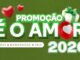 Banner promocional com fundo verde texturizado. No centro, o título Promoção É o Amor aparece em letras brancas com bordas verdes. A imagem inclui corações vermelhos, uma caixa de presente branca com laço verde e o ano 2026. Uma barra branca na parte inferior contém as palavras Mães, Namorados e Pais.