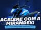 Motocicleta azul da marca Shineray em fundo azul escuro. Texto centralizado em letras brancas diz Acelere com a Mirandex. Abaixo, em destaque azul claro, está escrito que a compra vale uma moto 0km.