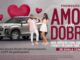 Banner publicitário da promoção Amor em Dobro com um carro SUV prata, duas mulheres celebrando e corações vermelhos flutuando sobre fundo cinza.