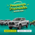 Banner publicitário da campanha Poupança Premiada SICOOB 2026 sobre fundo azul-turquesa. A imagem destaca uma picape Toyota Hilux prata no centro, flanqueada por três carros brancos à esquerda e três motos verdes à direita. No topo, o nome da promoção aparece em letras coloridas.