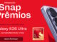Banner promocional da campanha Snap Prêmios com fundo vermelho, exibindo a lateral de um smartphone Galaxy S26 Ultra, o selo do processador Snapdragon 8 Elite e informações sobre o sorteio de uma camiseta do Manchester United.