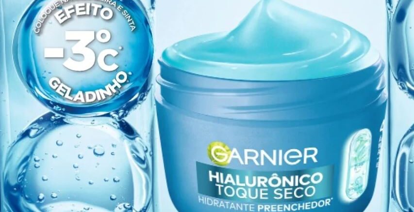 Receba Hialu Garnier Grátis Pote azul aberto de Garnier Hialurônico Toque Seco com gel azul claro e selo indicando sensação de menos três graus Celsius sob fundo com bolhas de água.
