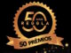 Selo comemorativo dourado dos 50 anos da Reggla com anúncio de 50 prêmios sobre fundo preto com brilhos.