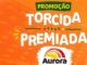 Banner promocional da Aurora com a frase Promoção Torcida Premiada escrita em letras brancas sobre um fundo laranja com padrão de estádio.