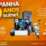 Banner promocional da Campanha 20 Anos Sulnet, com fundo laranja vibrante, exibindo prêmios como TV 65 polegadas, geladeira, ar-condicionado, scooter elétrica e patinete motorizado, destacando 20 prêmios disponíveis.