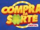 Logotipo Compra da Sorte Digital com letras amarelas tridimensionais, trevo verde e fundo azul com luzes circulares.