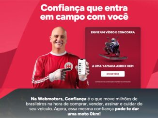 Banner promocional da campanha Confiança que Entra em Campo com Você, da Webmotors, com um homem sorridente vestindo uniforme de goleiro vermelho e segurando um smartphone, ao lado de um card com a imagem de uma moto Yamaha Aerox 0km e o botão Enviar Vídeo.