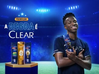 Peça publicitária da promoção "A Regra é Clear", da marca Clear Men, patrocinadora oficial da Copa do Mundo da FIFA 26, com atleta segurando frasco do produto em cenário de estádio iluminado.