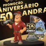 Banner da Promoção Aniversário 50 Anos Andra com mascote técnico em uniforme vermelho e colagem de fotos de viagens pelo Brasil.