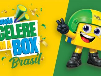 Mascote da Box Mania com capacete verde e amarelo, segurando uma bandeira do Brasil, ao lado do texto "Promoção Acelere com a Box Mania Brasil" sobre fundo verde e amarelo com confetes.