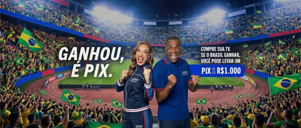 Peça publicitária da Casas Bahia com dois apresentadores uniformizados comemorando em um estádio lotado de torcedores com bandeiras do Brasil, ao lado do texto "Ganhou, é Pix" e a oferta de Pix de até R$1.000 para quem comprar uma TV e o Brasil ganhar.