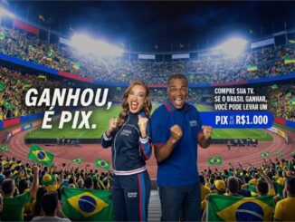 Peça publicitária da Casas Bahia com dois apresentadores uniformizados comemorando em um estádio lotado de torcedores com bandeiras do Brasil, ao lado do texto "Ganhou, é Pix" e a oferta de Pix de até R$1.000 para quem comprar uma TV e o Brasil ganhar.