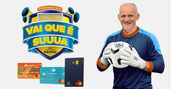 Promoção Vai que é Sua Atacadão com Goleiro Tafaréu Banner publicitário da promoção Vai que é Suuuua com o ex-goleiro Taffarel segurando uma bola de futebol autografada. O anúncio apresenta um logotipo temático de futebol e três cartões de crédito das redes Atacadão, Carrefour e Sam's Club.
