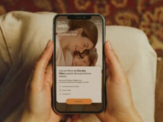 Mãos femininas seguram um smartphone exibindo a campanha de Dia das Mães da Natura, com a mensagem "o tempo passa, o cuidado fica" e a opção de criar um filme personalizado com fotos e vídeos.
