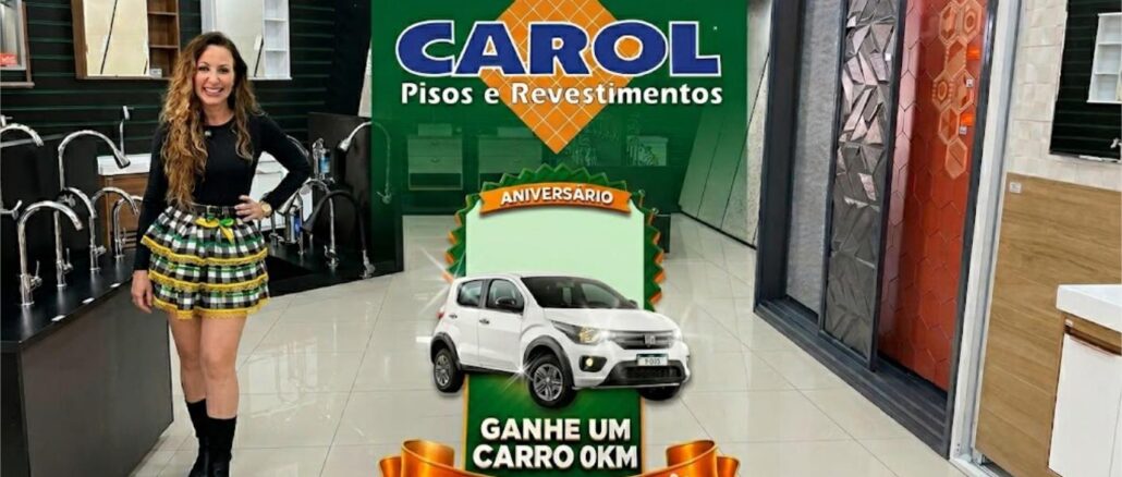 ANIVERSARIO CAROL PISOS 2026 Mulher sorridente em um showroom de acabamentos ao lado de um banner de aniversário que destaca o prêmio de um carro zero quilômetro.