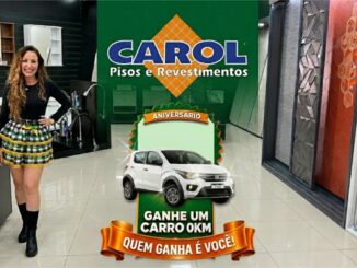 Mulher sorridente em um showroom de acabamentos ao lado de um banner de aniversário que destaca o prêmio de um carro zero quilômetro.