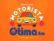 Arte da Promoção Motorista Otimista da rádio Ótima FM, com ilustração de carro animado sorridente em fundo laranja.