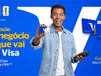 Homem negro sorridente segurando um cartão de crédito Visa e uma máquina de cartões sobre um fundo azul com elementos da marca e da Copa do Mundo da FIFA.