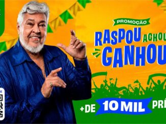 Homem de cabelos e barba branca sorri e gesticula em frente a um fundo amarelo com elementos da seleção brasileira e o texto Promoção Raspou Achou Ganhou.