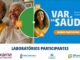 Banner publicitário da campanha Var da Saúde apresentando fotos de pessoas sorridentes e logotipos de laboratórios parceiros.