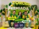 Três torcedores com as cores do Brasil comemoram em sofá, cercados por presentes e troféus, na promoção Torcida Premiada do Zat Supermercados.
