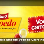 Banner amarelo e vermelho da promoção Aniversário Amoedo Você de Carro Novo 2026, com faixa vermelha escrito Aniversário Amoedo da Construção à Decoração e letreiro luminoso vermelho com a frase Você de carro 0km, decorado com confetes e balões vermelho e branco