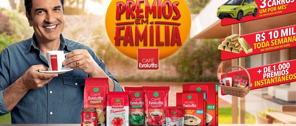 Prêmios em Família Café Evolutto Ator sorridente segura xícara de Café Evolutto ao lado de embalagens dos produtos da marca e banner amarelo da Promoção Prêmios em Família, com destaque para prêmios de 3 carros, R$10 mil por semana e mais de 1.000 prêmios instantâneos.