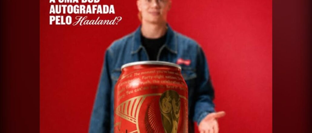 Promoção Budweiser na Copa Homem loiro vestindo jaqueta jeans segura lata gigante de cerveja Budweiser com estampa da Copa do Mundo, ao lado do texto "Quer concorrer a uma Bud autografada pelo Haaland?" sobre fundo vermelho.