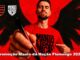 Homem com barba veste camiseta vermelha escrita Manto da Nação, aponta caneta para a câmera, com escudo do Flamengo e logo Manto da Nação ao fundo vermelho com asas negras