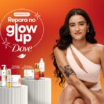 Banner da promoção Repara no Glow Up Dove, com selo circular branco escrito Promoção Repara no Glow Up Dove sobre fundo gradiente laranja e vermelho, exibindo à direita uma mulher de cabelos longos e cacheados castanho-escuros sentada, usando um top branco assimétrico, com tatuagens no braço, e à esquerda produtos Dove das linhas Pele e Cabelo dispostos sobre pedestais cilíndricos claros.
