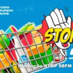 Banner azul da Promoção Stop 98FM Curitiba mostrando um carrinho de compras cheio de produtos alimentícios e de limpeza, com uma mão em formato de sinal de pare e a palavra STOP em amarelo ao lado do logotipo da rádio 98FM.